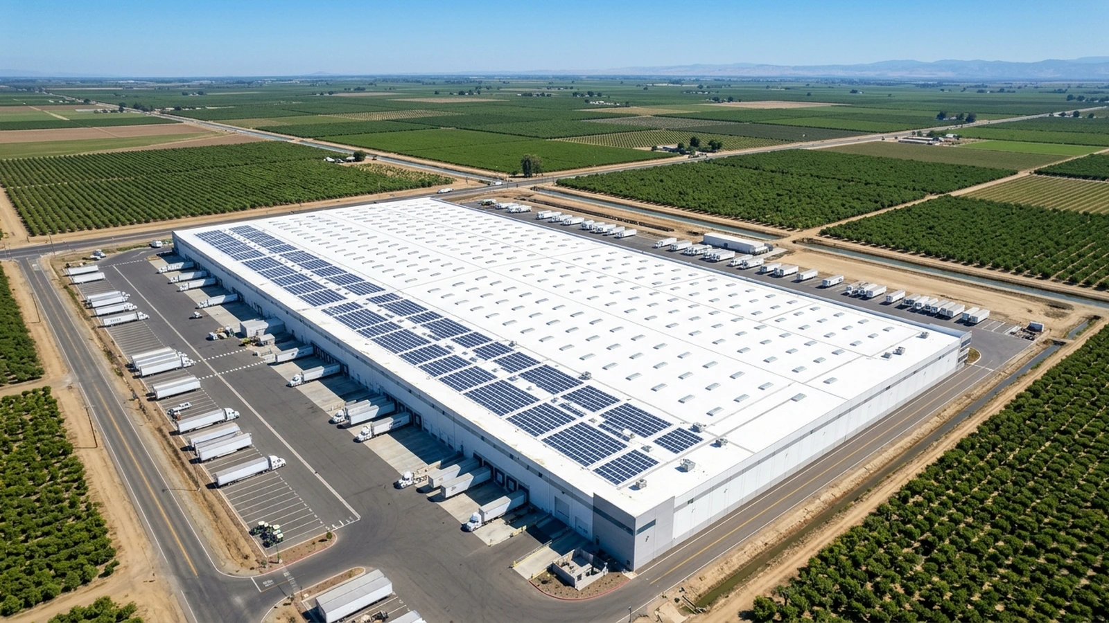 Aerial view of an industrial flat-roof warehouse in Fresno with skylights and solar array mounts